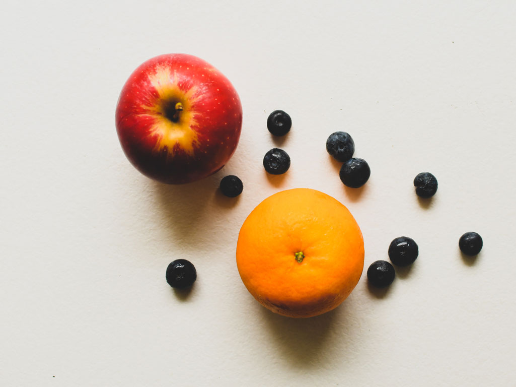 Apple, orange, and blueberries on a table