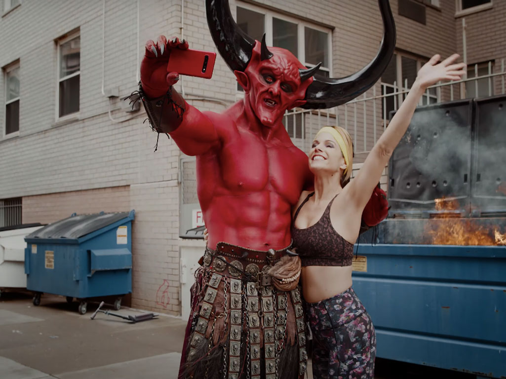 Match.com commercial showing the devil and a woman named 2020 in front of a dumpster fire
