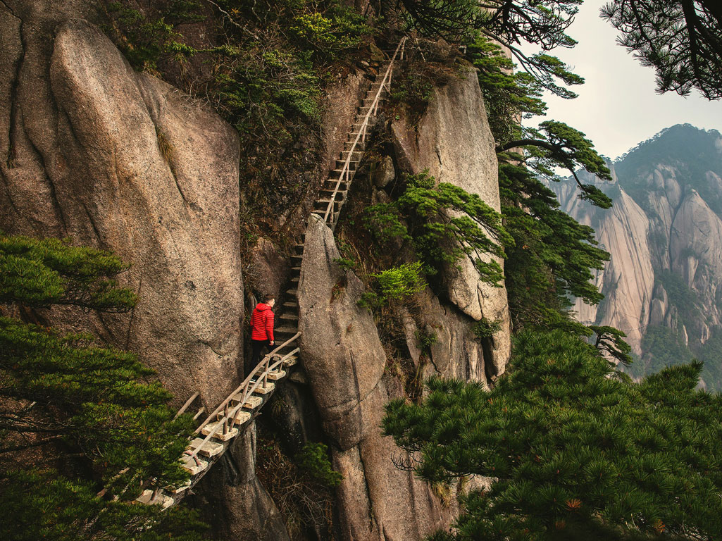 Hiker climbing stairs to mountain summit