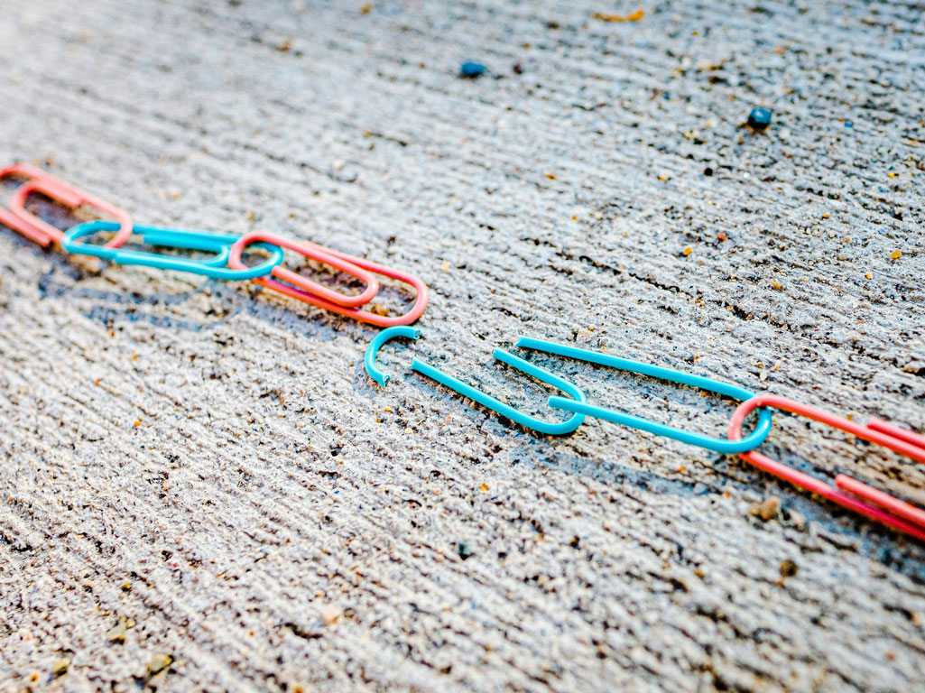 Broken paper clip in a chain of paper clips